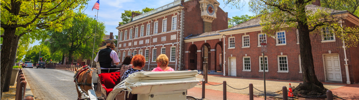 People riding a carriage outside of Indepedence Hall.